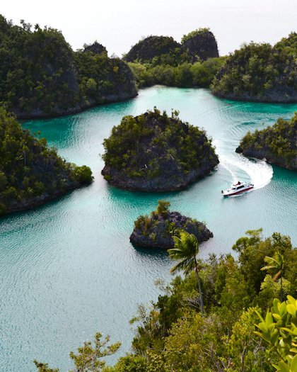 Green islands scattered across clear turquoise water in Indonesia