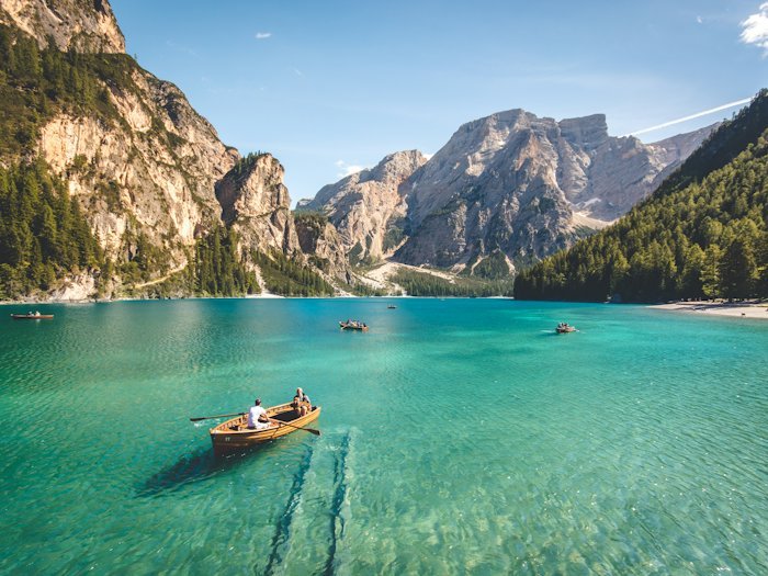 A wooden boat on a still mountain lake at first light