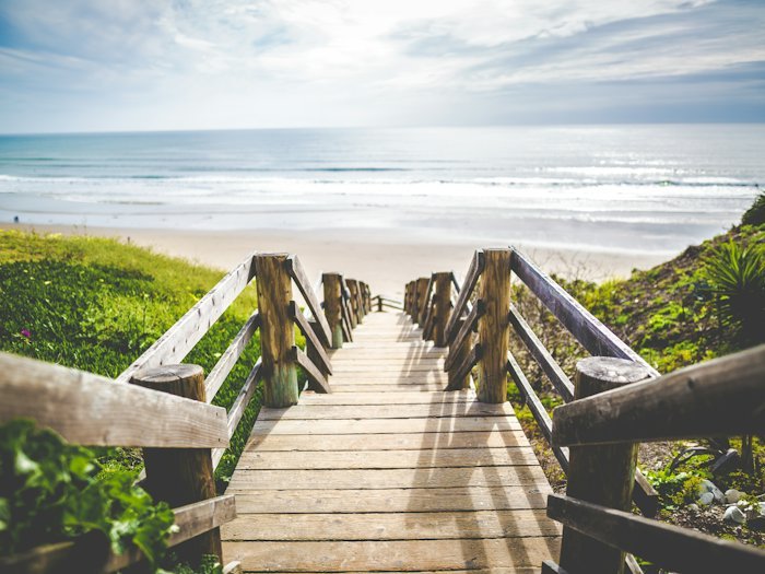 A wooden boardwalk running down to a quiet shoreline