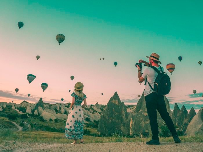 Hot air balloons rising at sunrise over a valley