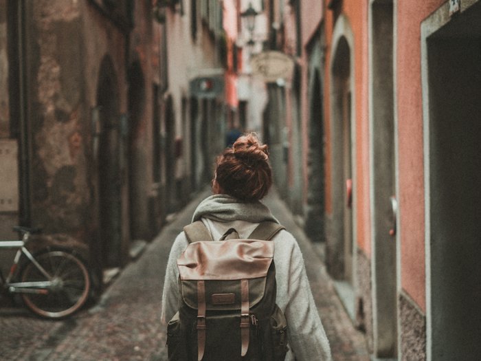 A traveller with a backpack exploring a narrow old street