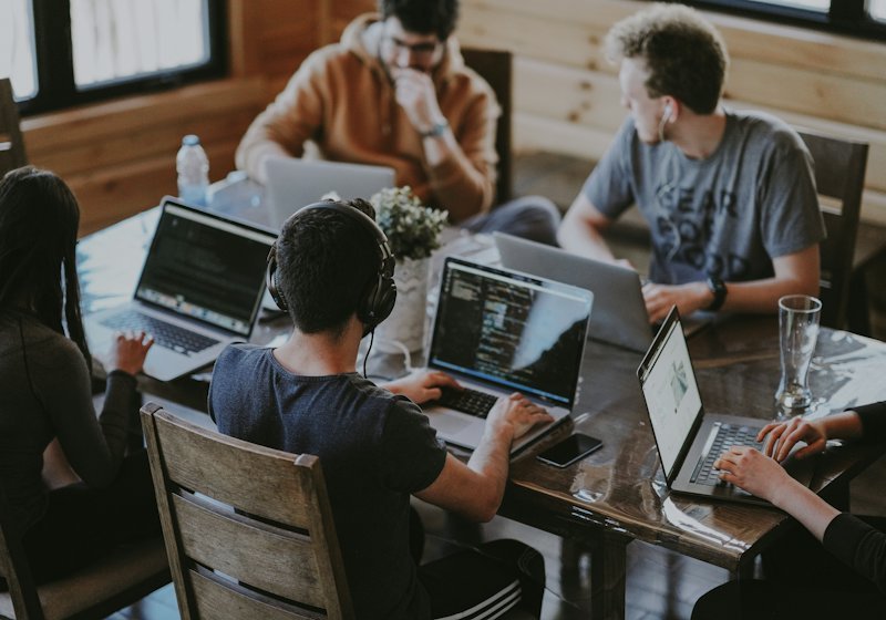 A team working together around laptops at a shared table