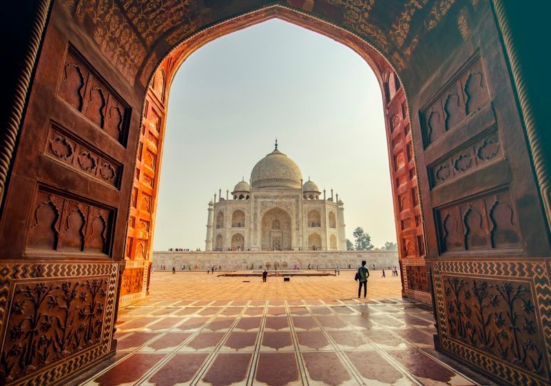 The Taj Mahal framed by a carved sandstone archway in Agra