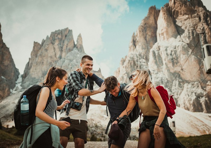 A group of travellers laughing together on a hiking trail