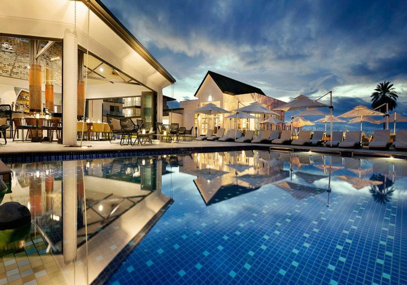 A quiet hotel swimming pool lit at dusk